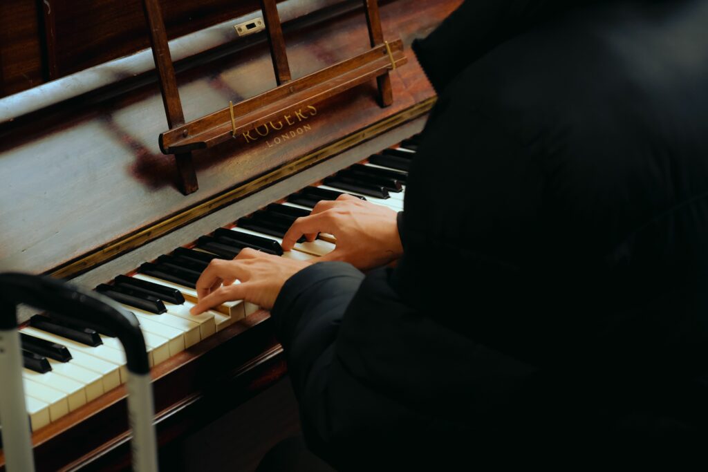 Personne jouant du piano sur un piano droit