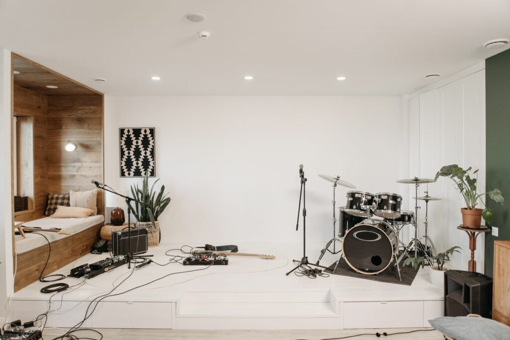 Studio de répétition équipé d'une batterie, de microphone et de matériel de musique.